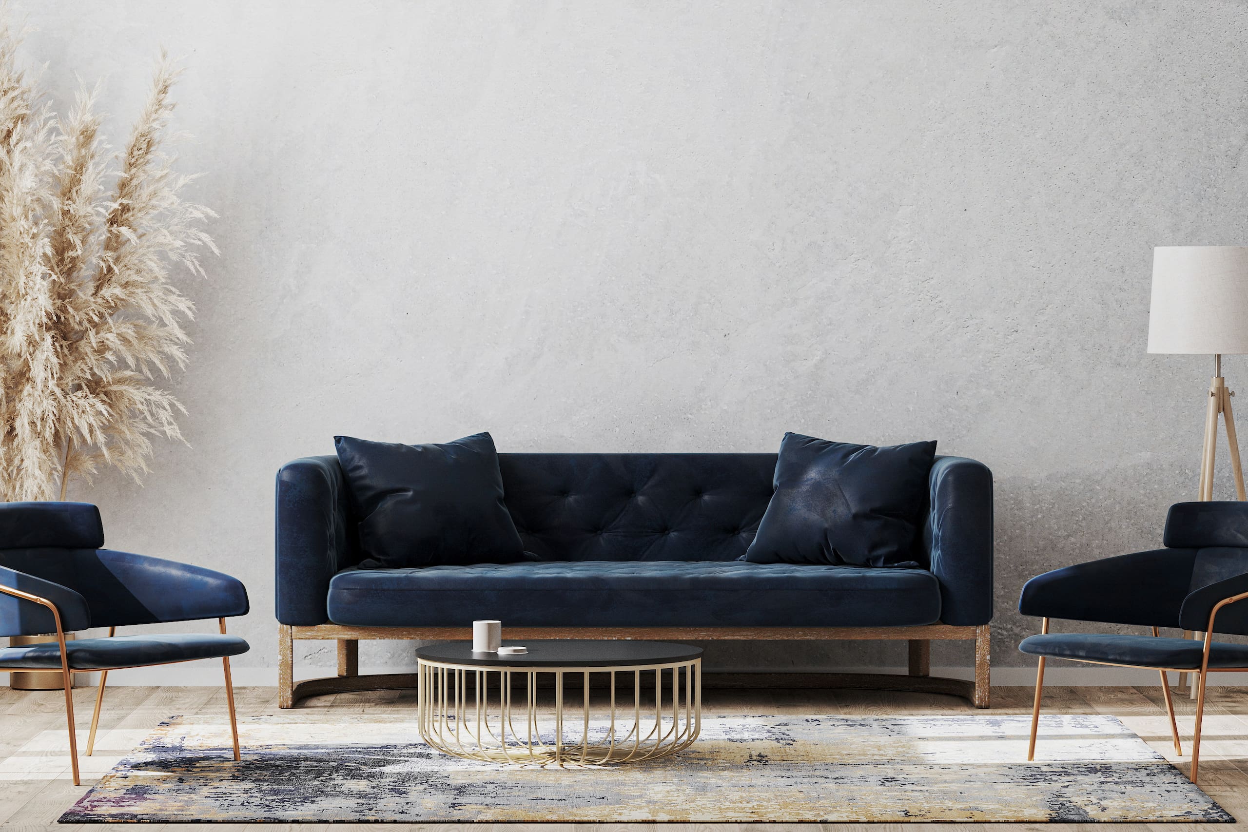 Living room setting with dark blue sofa, two chairs, round coffee table on top of a rug