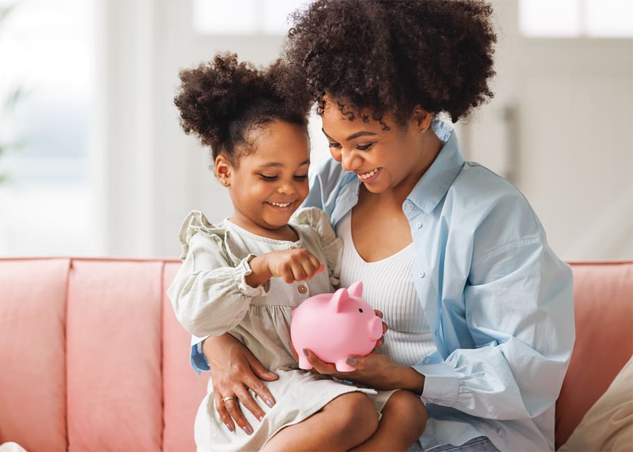 a woman holding a child and a piggy bank