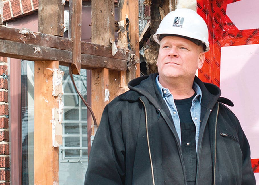 man looking up in front of home restoration
