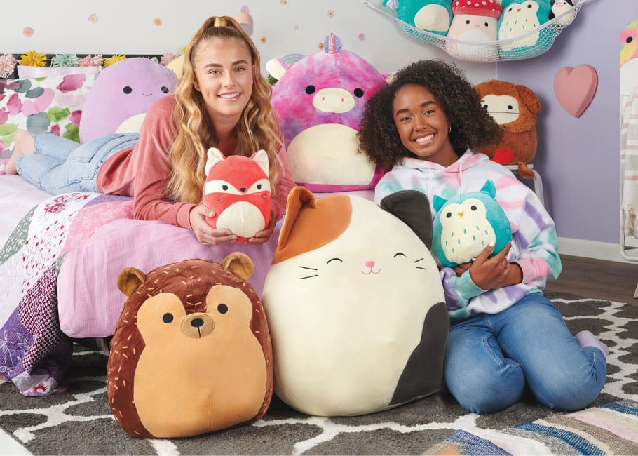 girls hold squishmallows