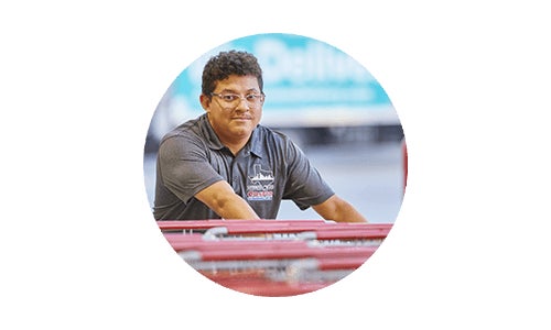 Costco employee pushing carts at Costco warehouse