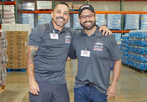 Two Costco employees from the Dallas team with arms around shoulders - inclusion belonging