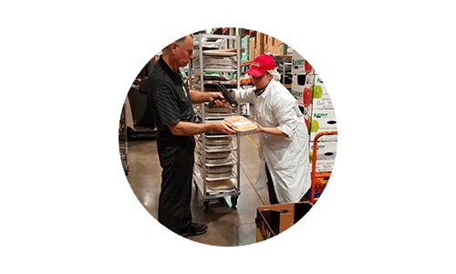 Man scanning Costco food donation at warehouse for charitable giving to community
