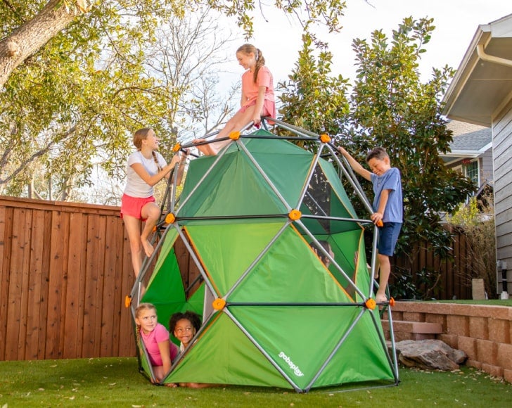 Two children playing in a wooden playhouse