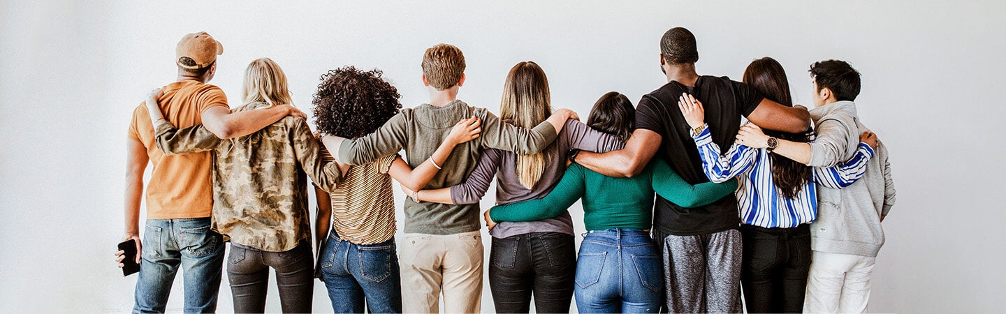 Line of diverse people with arms around shoulders facing away from camera