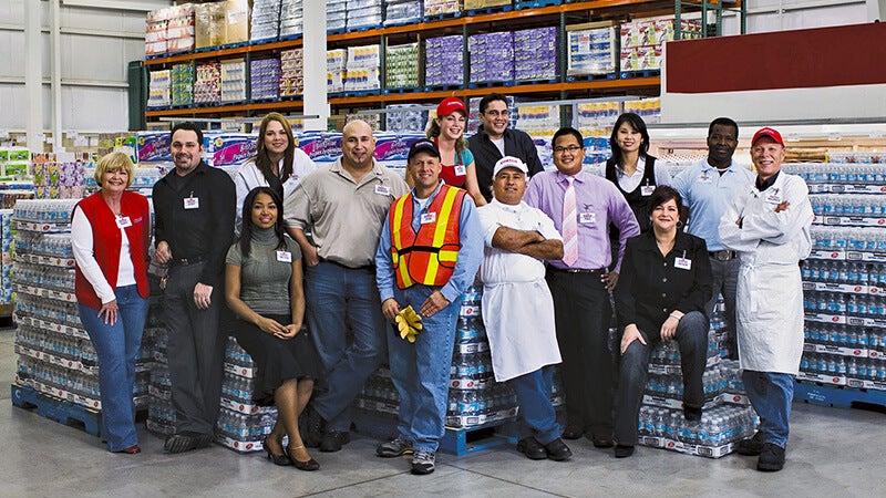 Costco employees from a variety of roles pose in warehouse