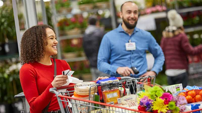 Costco shopper with full cart of products at Costco warehouse
