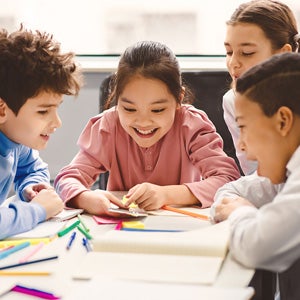 Group of children drawing around a table
