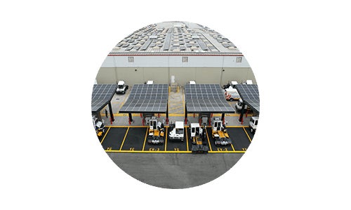 Solar panels charging electric yard tractors at Costco depot in Mira Loma